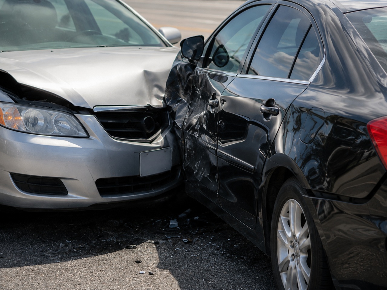 Close up of two vehicles with heavy front end and side collision damage on a Texas roadway, illustrating a car accident case subject to the state's lawsuit filing deadline.